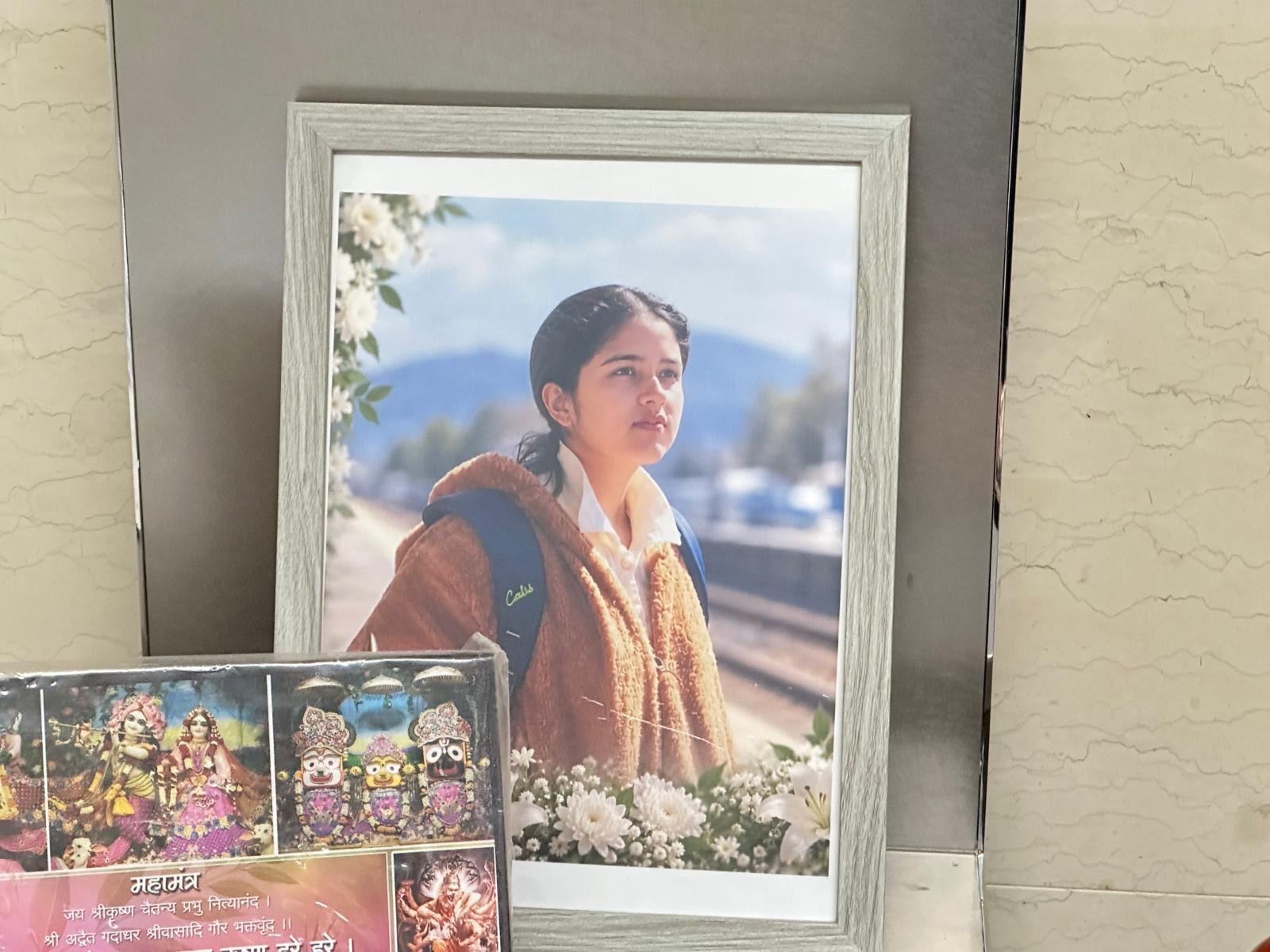 A closer view of the memorial altar for Devika, with her photograph and ritual offerings.